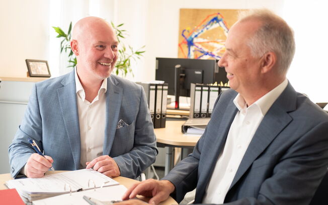 Thilo Bremer und Frank Niederklapfer gehen gemeinsam einige Unterlagen durch.