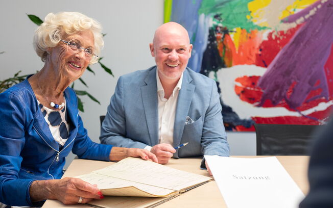 Anke Riefers und Thilo Bremer sitzen lächelnd gemeinsam an einem Tisch.